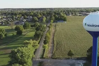 Marshfield, MO water tower beside green fields and neighborhoods